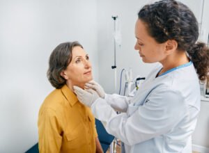 a woman getting checked by a medical professional for hypothyroidism