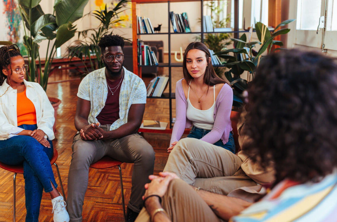 Diverse young people having group therapy session.