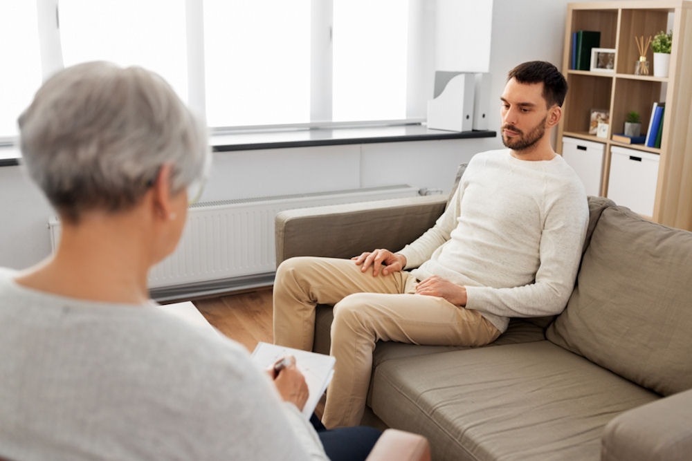 man with addiction talking to his therapist