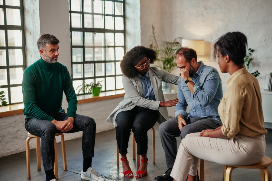 Several professionals sitting on chairs, participating in a group therapy