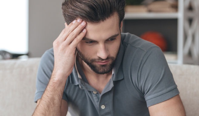 a man holding his head showing symptoms of pain