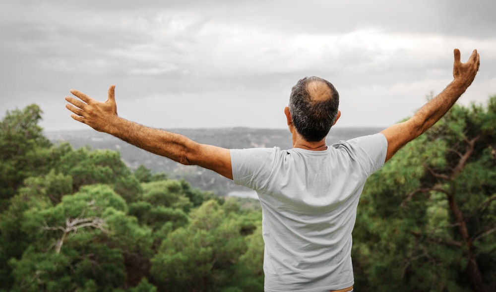 Man embracing nature as a symbol of sobriety and freedom